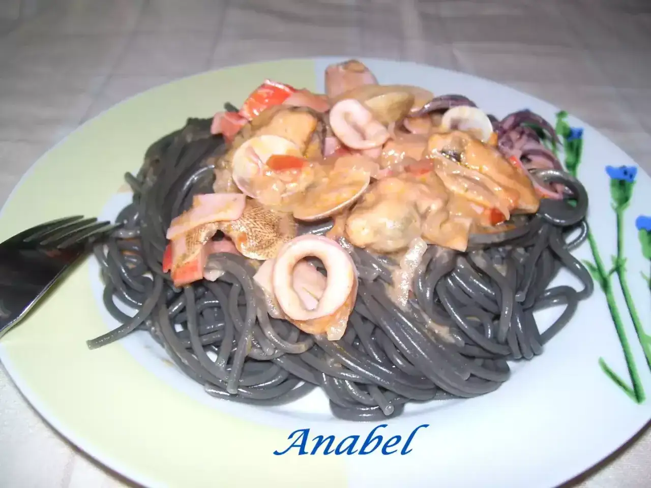 Espaguetis negro con nata y mariscos, un plato delicioso y visualmente impactante.