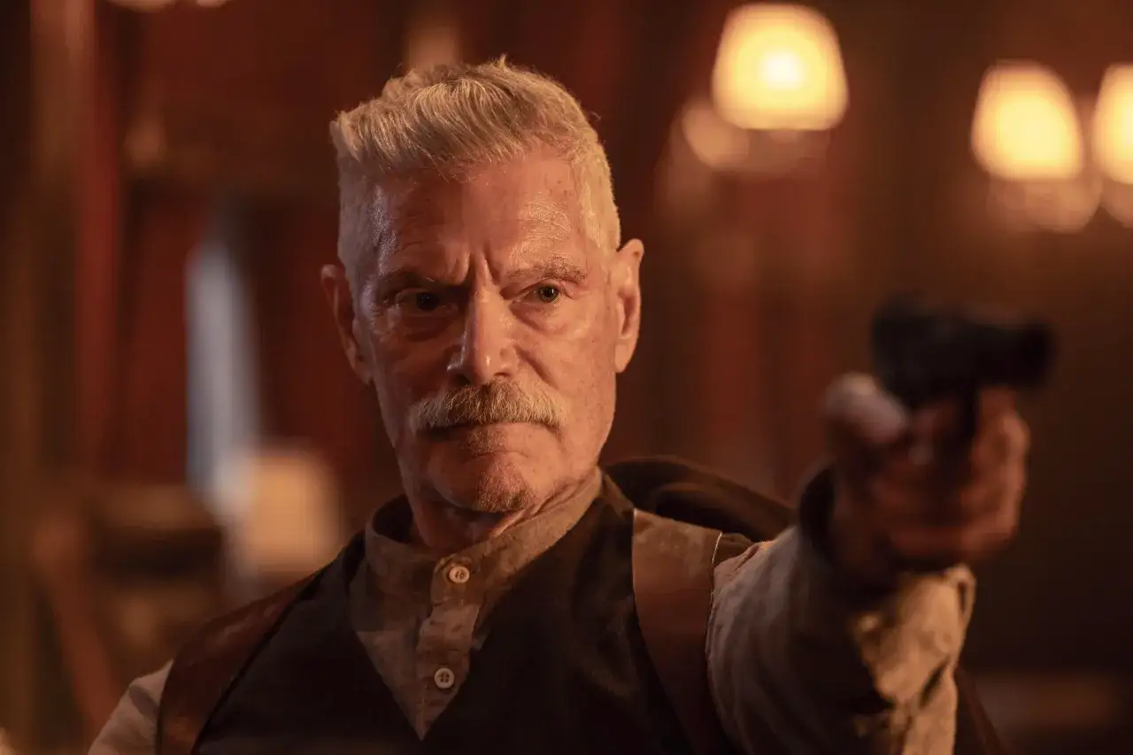 Stephen Lang w filmach, z pistoletem w dłoni, w westernowym stroju, z groźnym spojrzeniem.