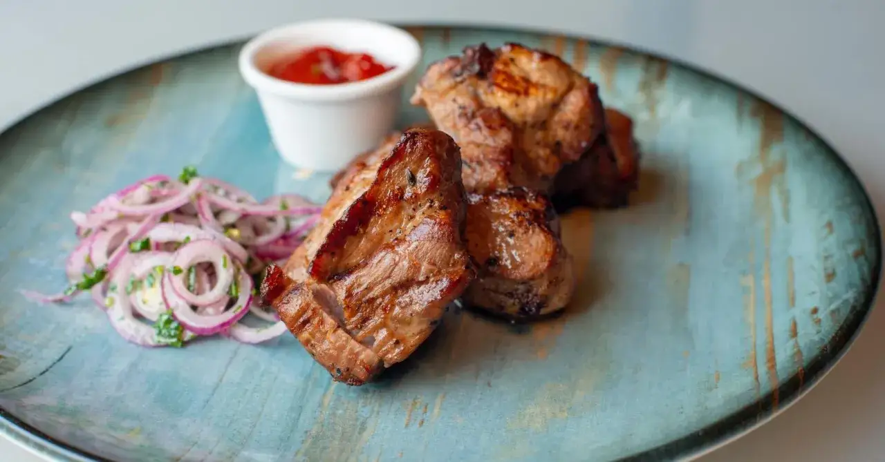 Soczyste mięso wołowe kebab, podane z czerwoną cebulką i sosem. Idealne na letni grill.