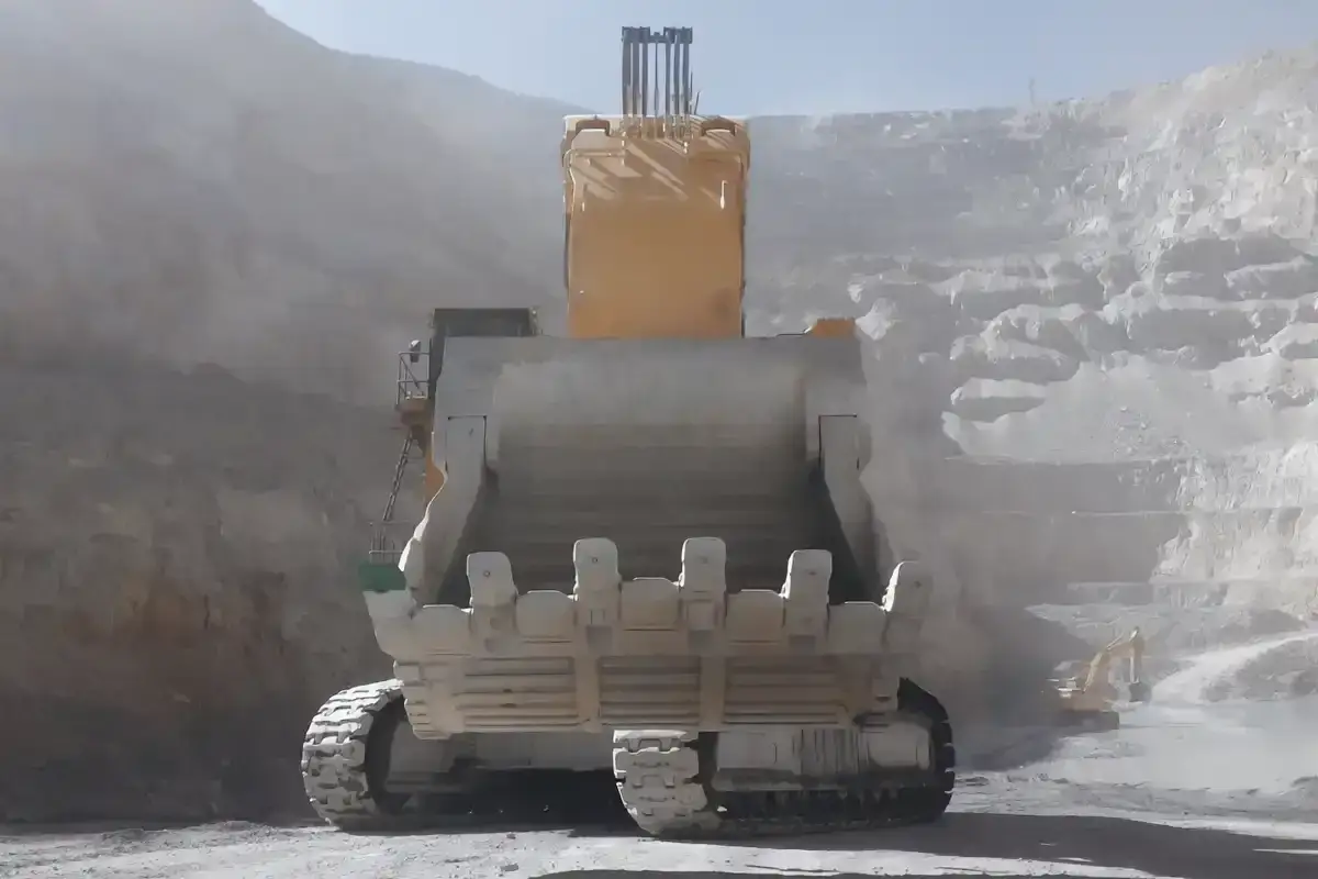 Ogromna, żółta koparka Komatsu, największa koparka Komatsu, pracuje w kopalni, zasypując zbocza skalne.