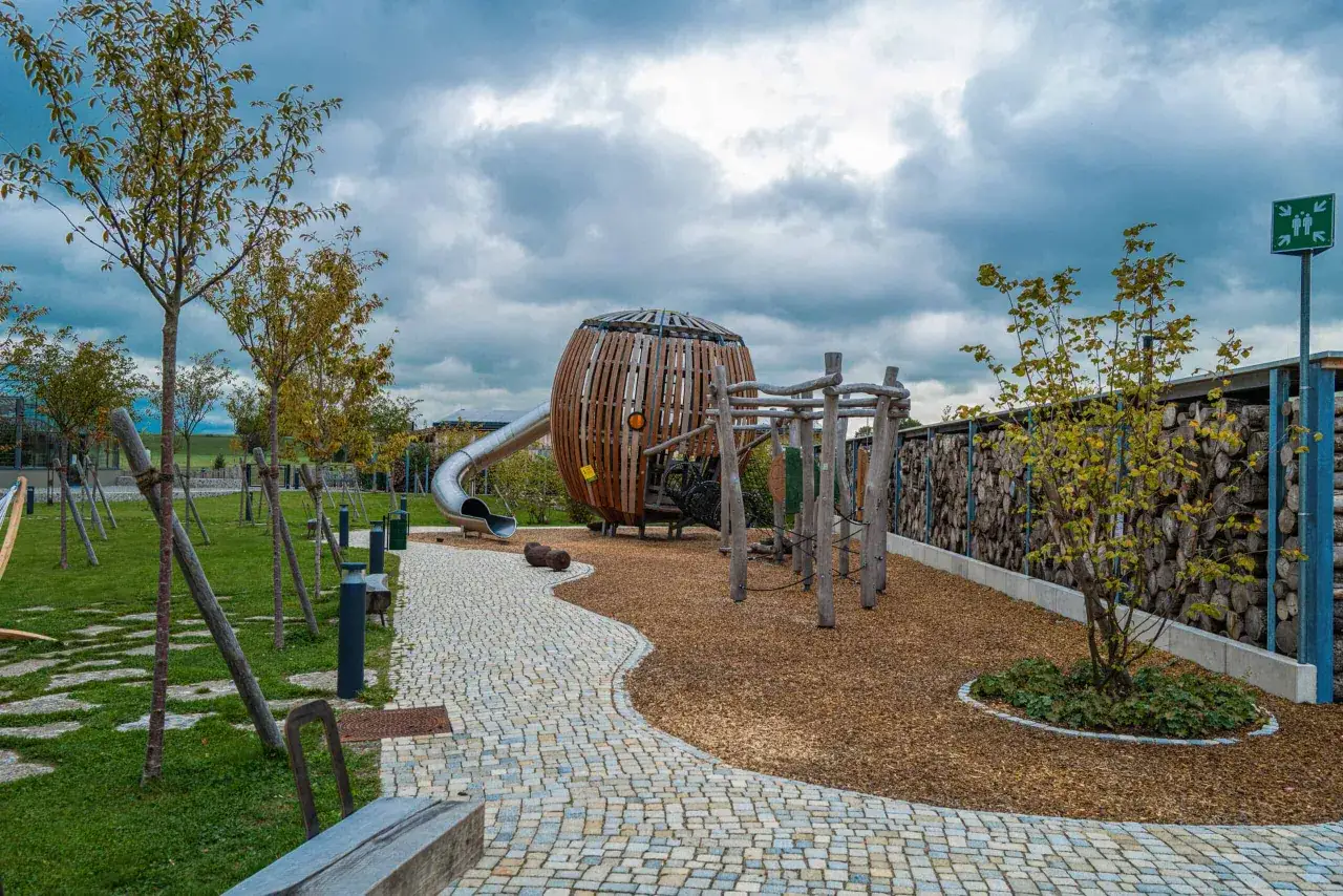 Ein Spielplatz, der an die Rapunzel Welt erinnert, mit einer Rutsche, einem Kletterger&uuml;st und einem gro&szlig;en Holzkugel-Turm.