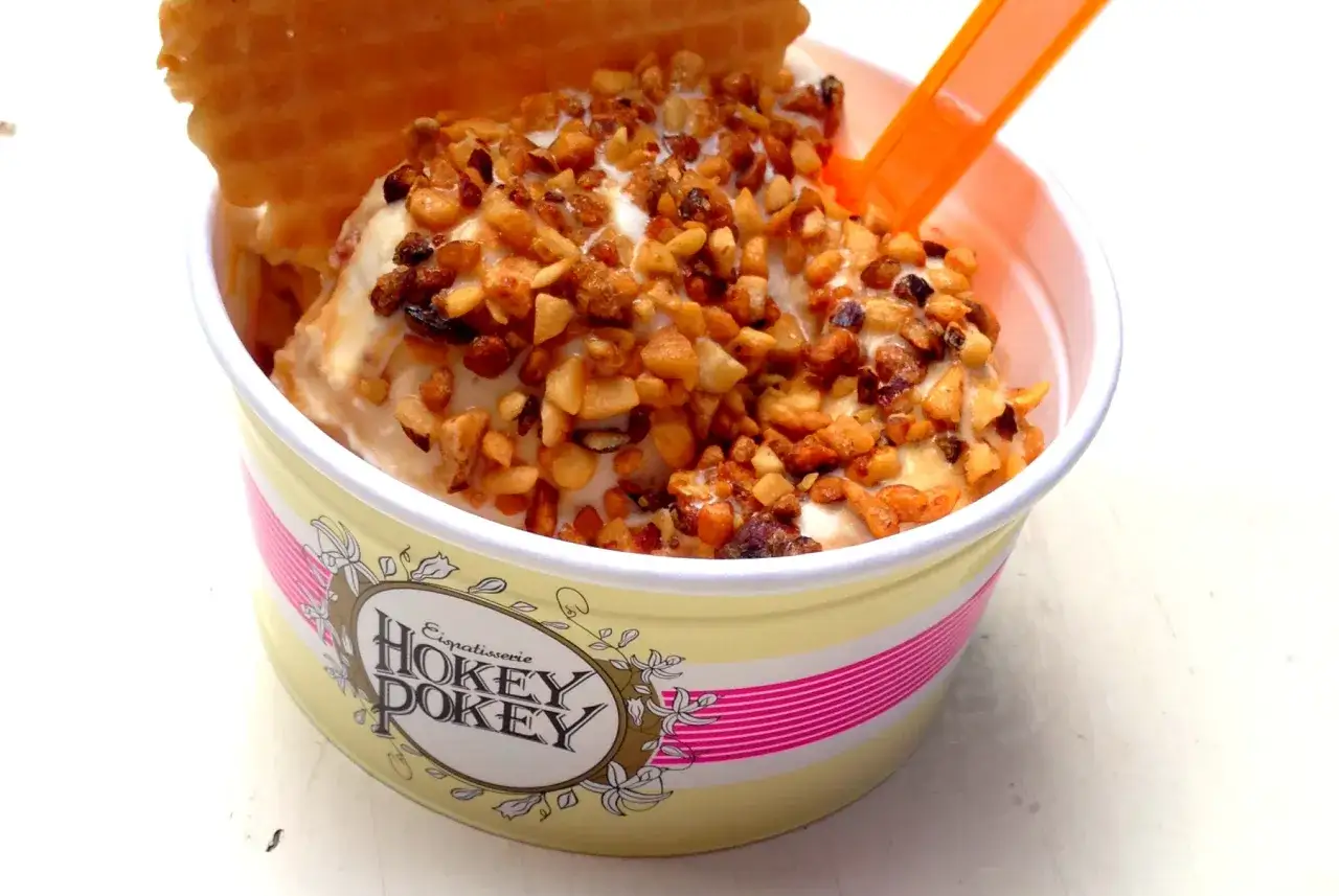 Ein Becher Hokey Pokey Eis mit Nüssen und Waffel. Perfekt für ein süßes Hokey Pokey Eis Rezept.