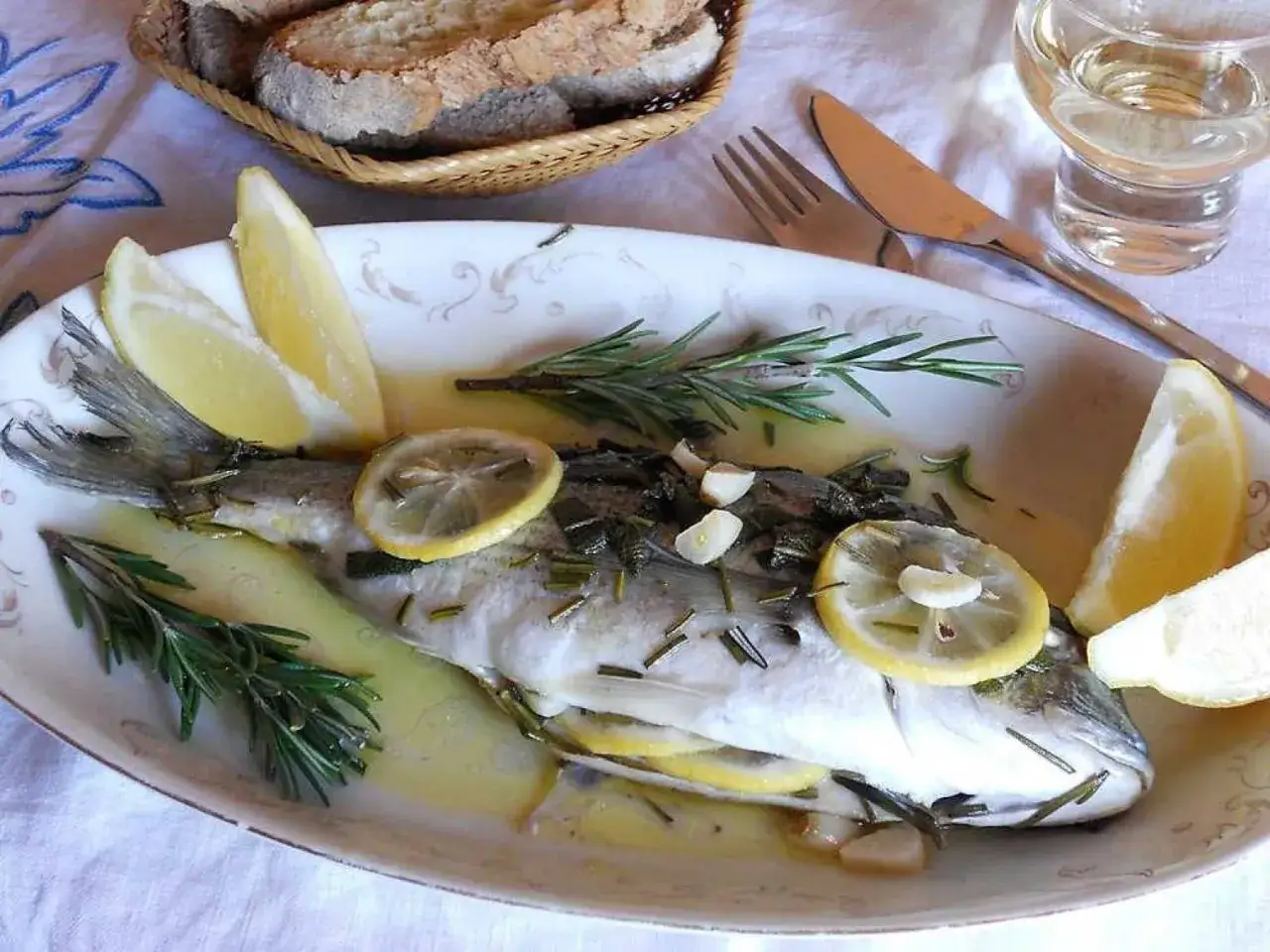 Orata al cartoccio, un piatto profumato con limone, rosmarino e aglio, pronto per essere gustato.