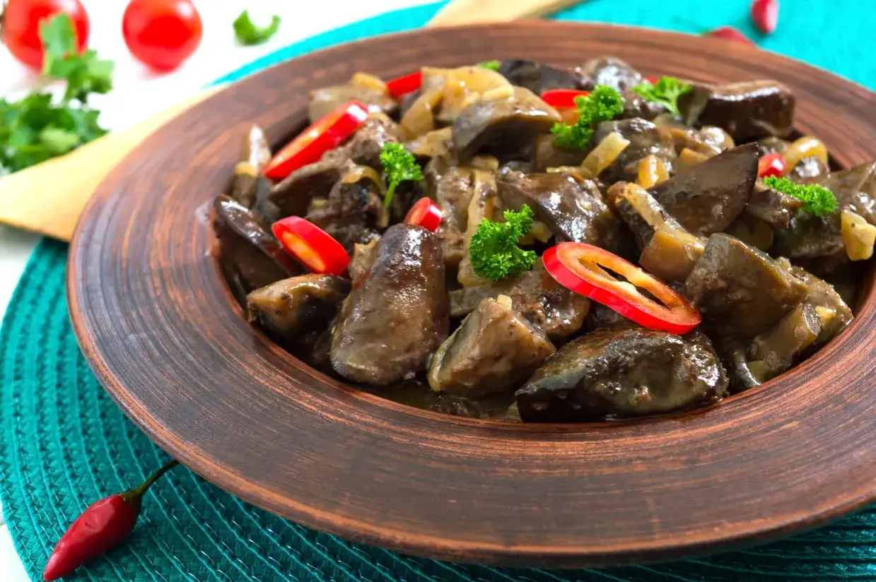 D&eacute;licieux foie de volaille po&ecirc;l&eacute; avec oignons, persil et piment rouge. Un plat savoureux pr&ecirc;t pour la cuisson.