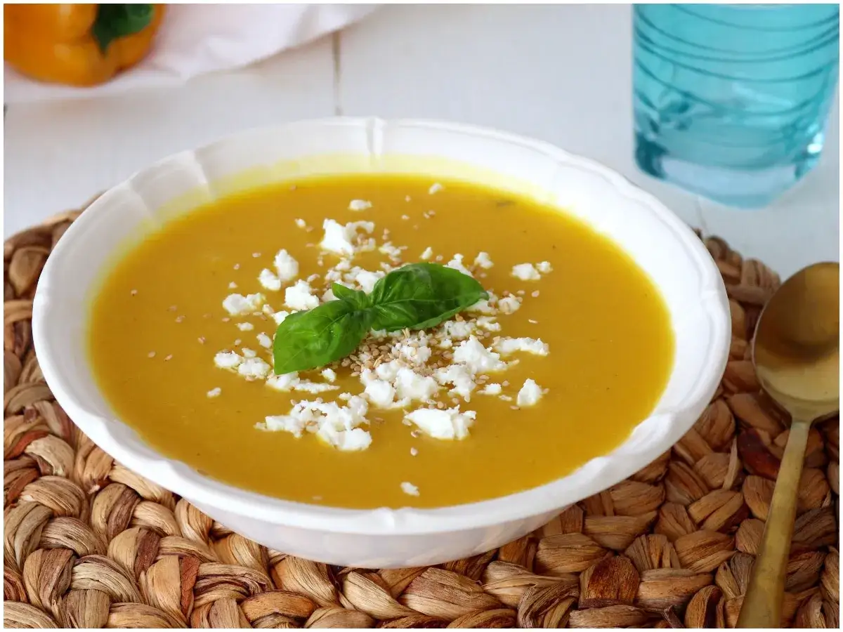 Crema di peperoni vellutata, guarnita con feta sbriciolata, basilico fresco e semi di sesamo. Un piatto invitante e saporito.