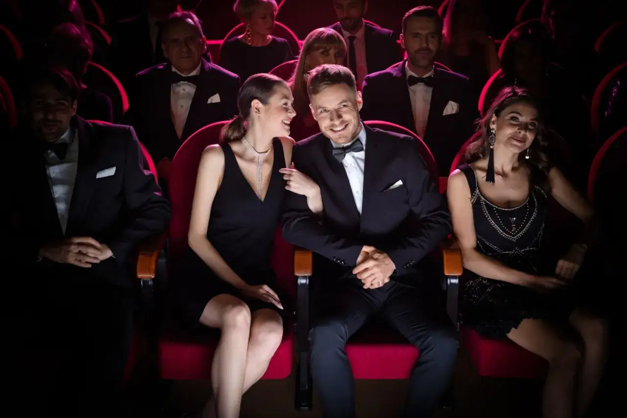 Elegant gekleidet: Ein Paar in Abendgarderobe, was zieht man in die Oper an? Sie tr&auml;gt ein schwarzes Kleid, er einen Anzug mit Fliege.