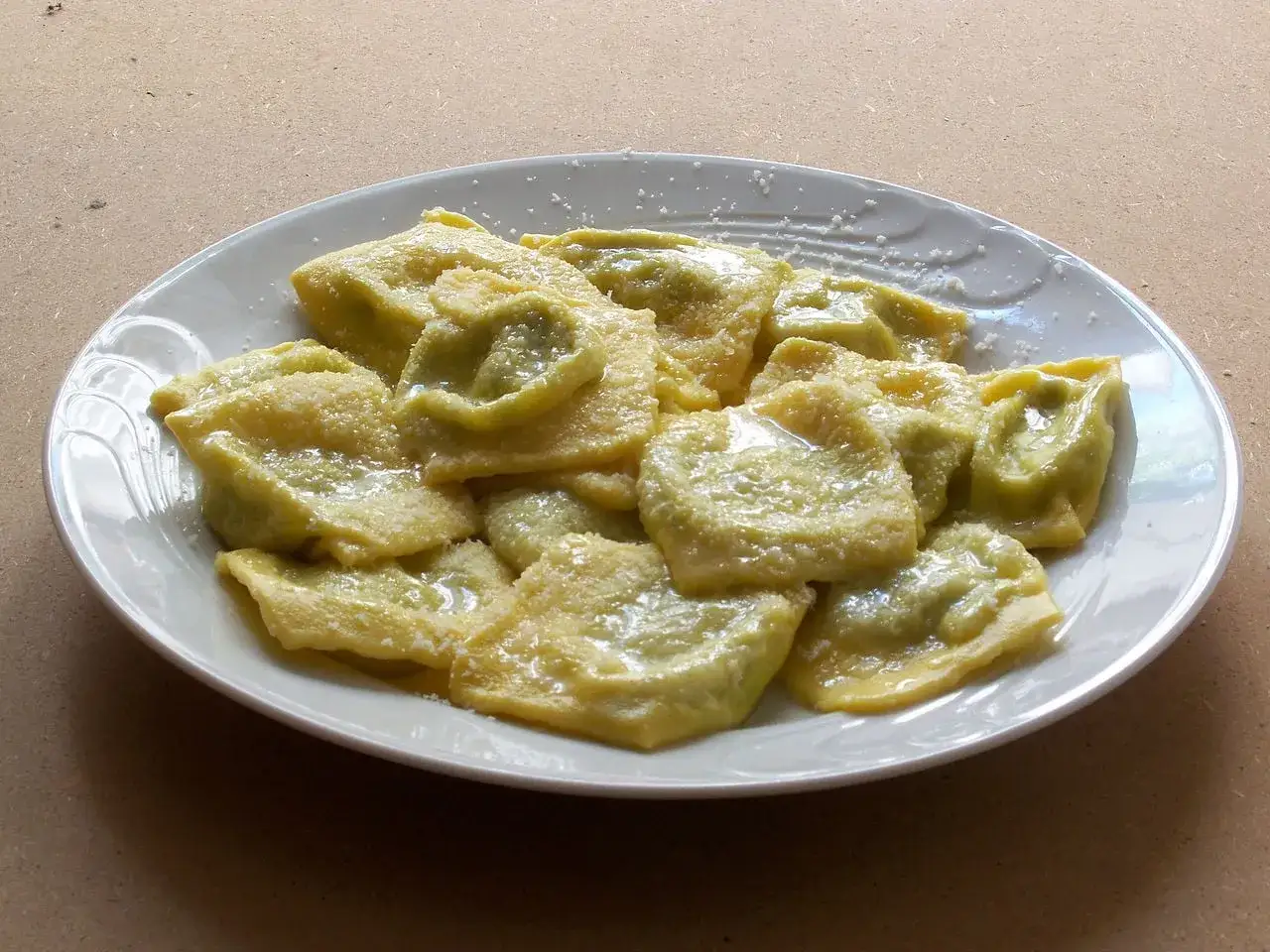 Ravioli verdi conditi con burro e parmigiano, un assaggio dei piatti tipici di Parma.
