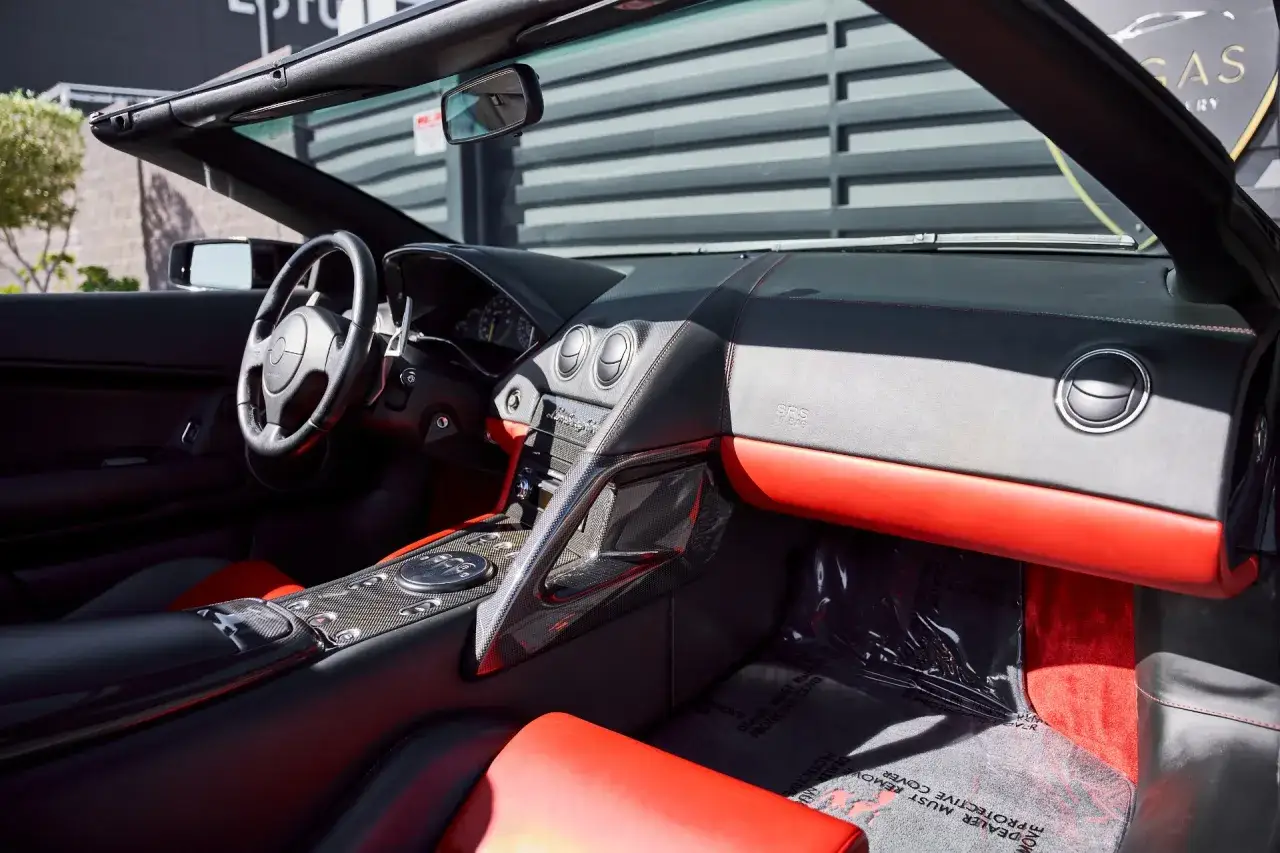 Wnętrze kabrioletu Lamborghini Murciélago z czerwono-czarną tapicerką i elementami z włókna węglowego.