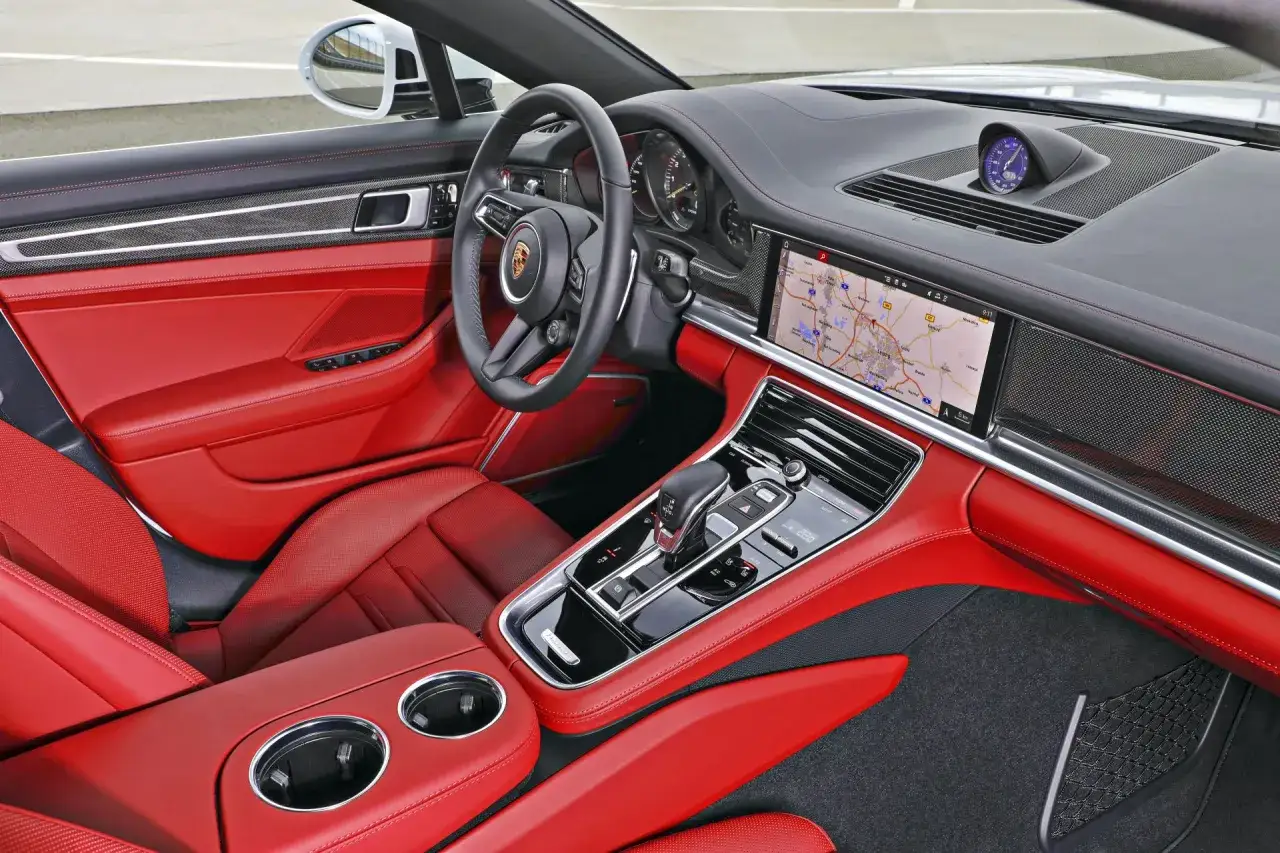 Wnętrze Porsche Panamera GTS z czerwonymi skórzanymi fotelami i nowoczesnym panelem sterowania.
