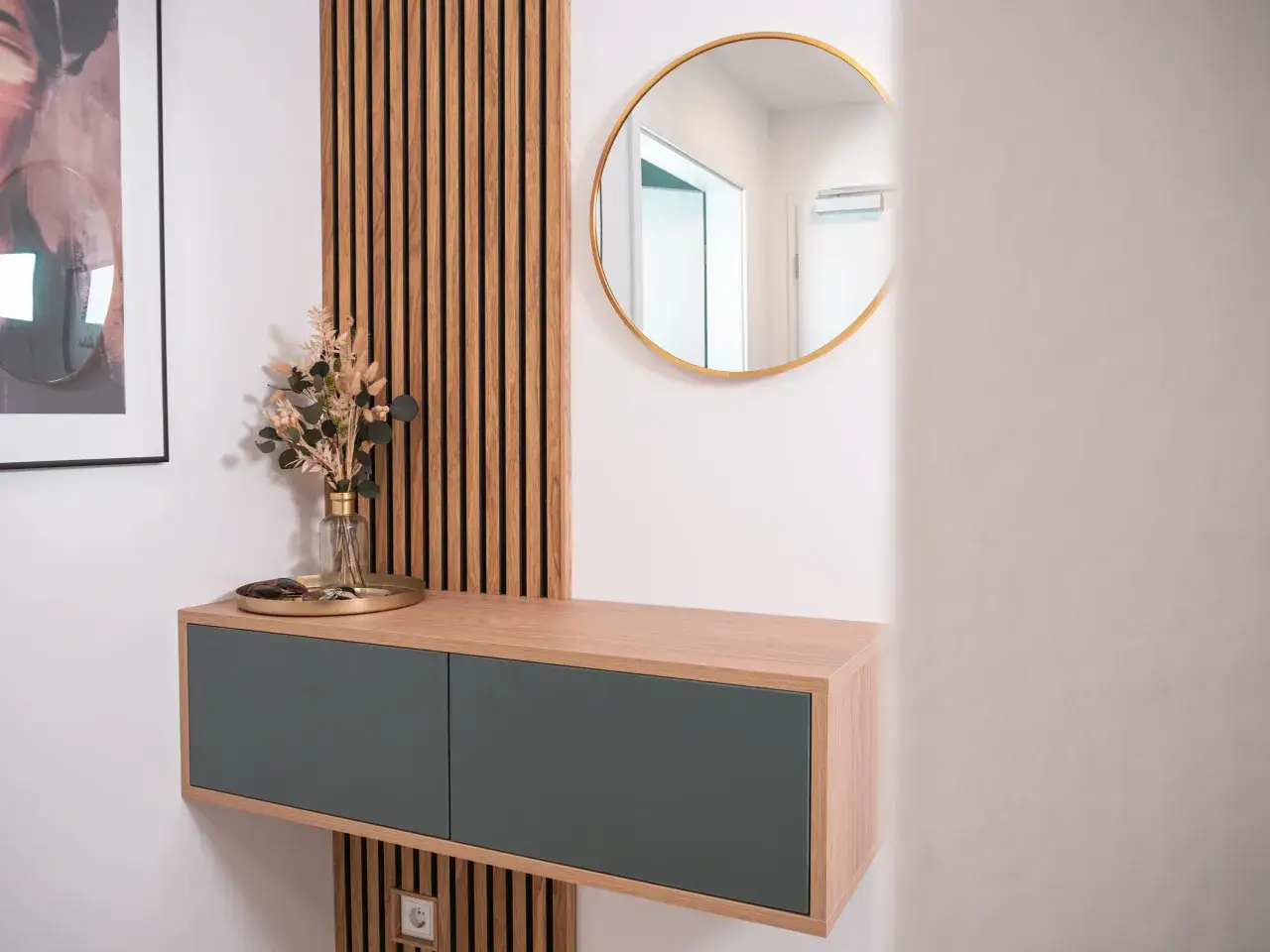 Schmaler Flur Ideen: H&auml;ngendes Sideboard mit zwei grauen Schubladen, goldener Spiegel und Holzlamellenwand. Deko-Zweig und Tablett mit Schl&uuml;sseln.