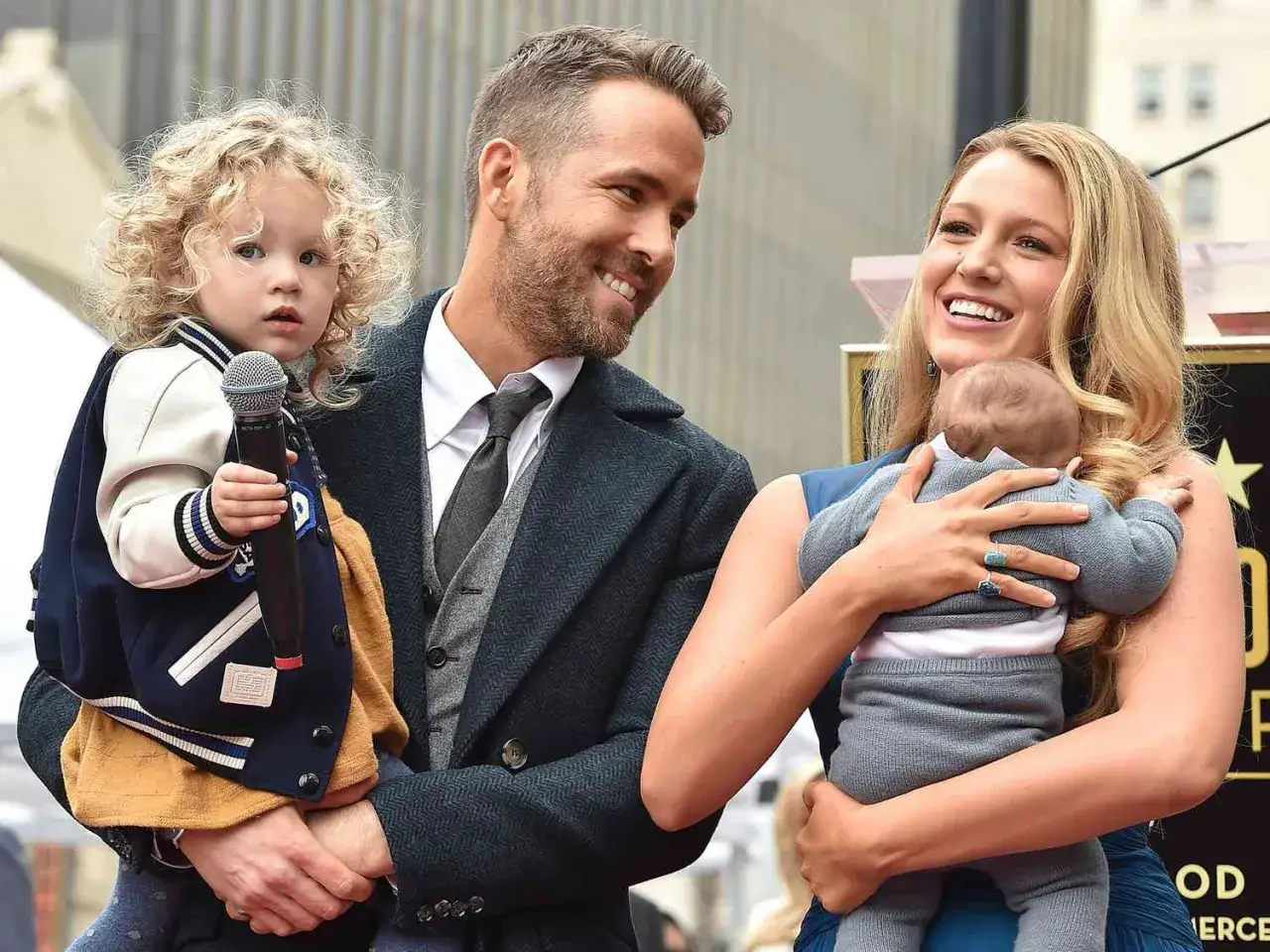 Ryan Reynolds i Blake Lively z ich blake lively dzieci. Jedno dziecko trzyma mikrofon, drugie tuli się do mamy.