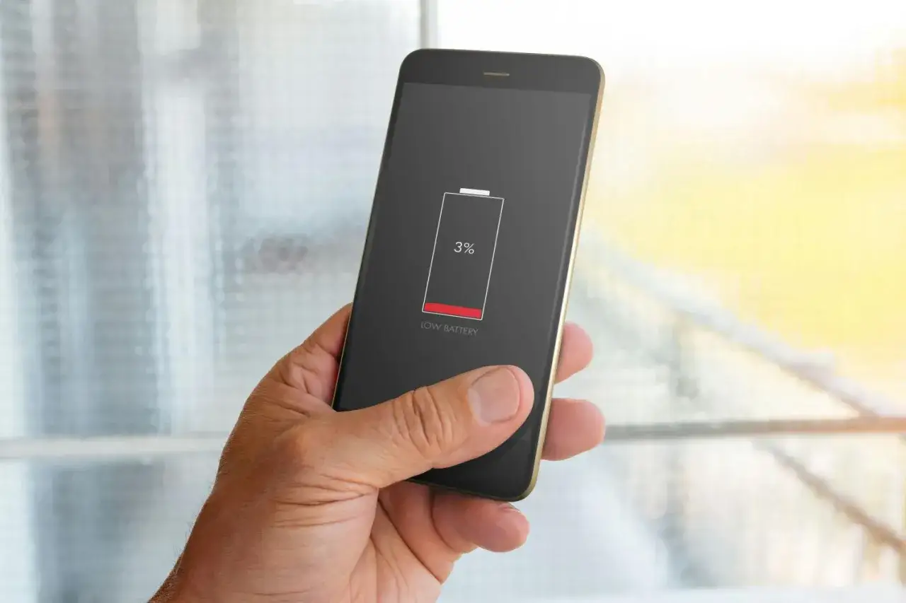 En hand h&aring;ller en mobil med l&aring;gt batteri (3%). Dags att kolla vilka appar som drar mest batteri.