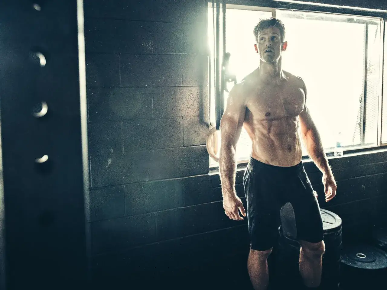 Ein Mann mit durchtrainiertem K&ouml;rper steht im Fitnessstudio. Sein Ziel: fettfrei Muskeln aufbauen.