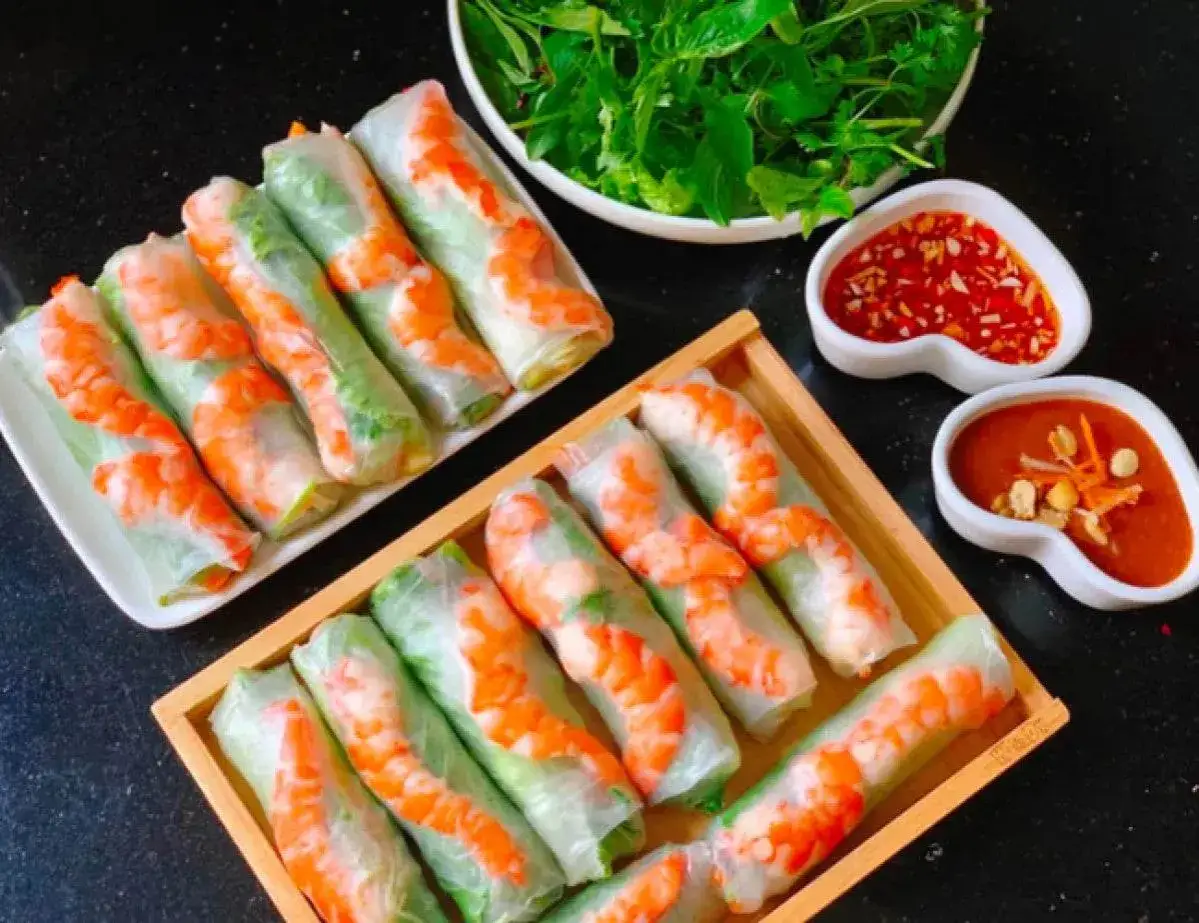 Deux plateaux de rouleaux de printemps frais, garnis de crevettes et de l&eacute;gumes verts, accompagn&eacute;s de sauces pour tremper.