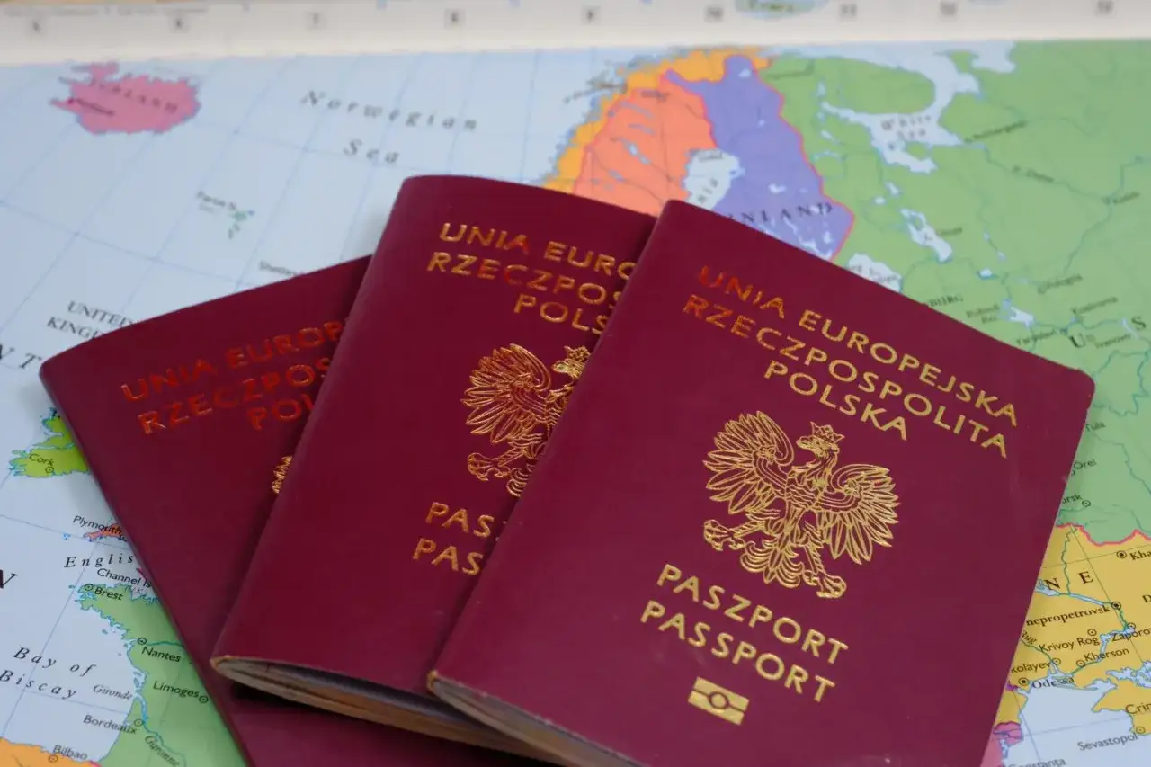 Trzy polskie paszporty leżą na mapie Europy, gotowe do podróży. Planujesz wiza do Anglii?