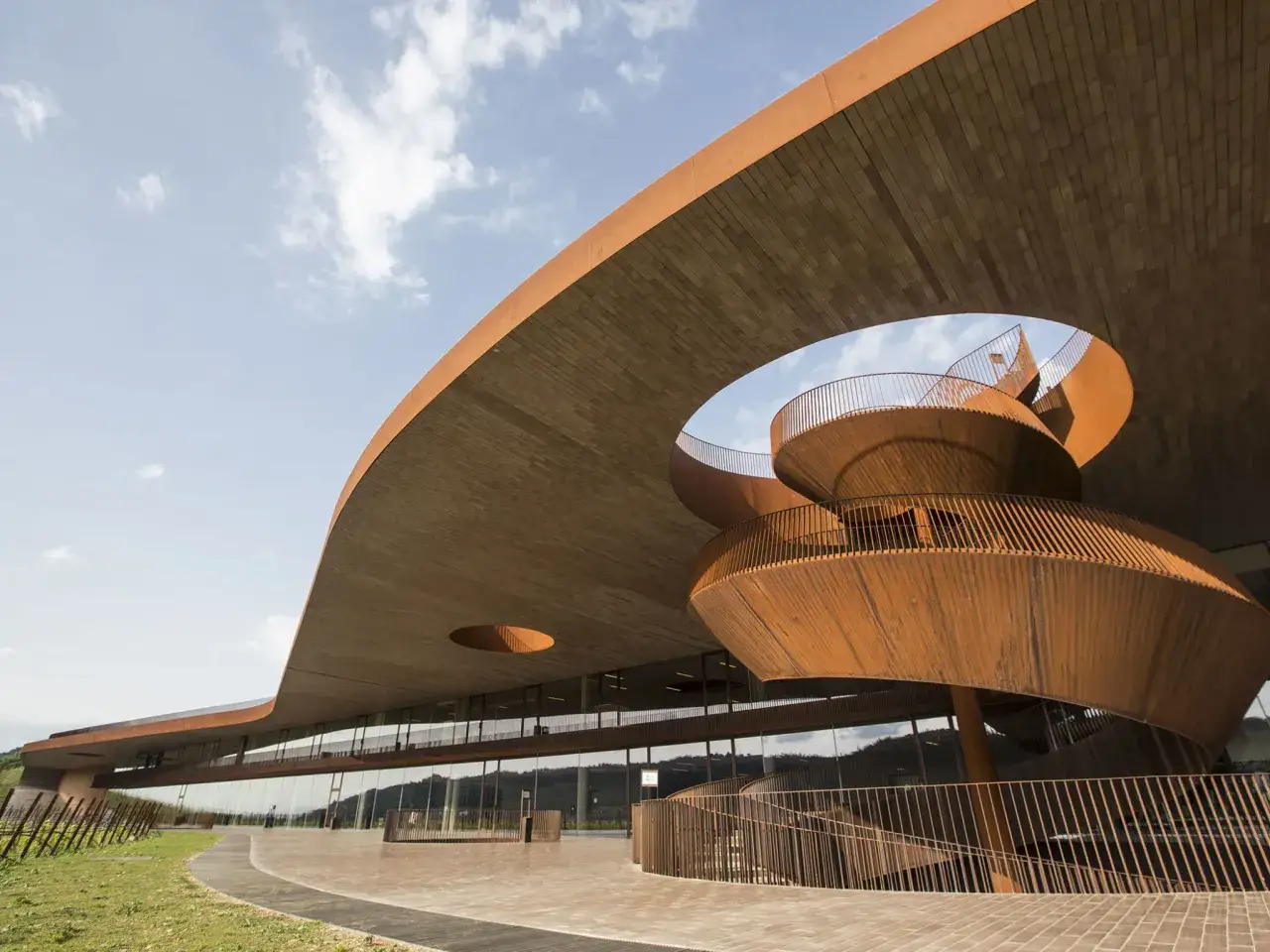Moderna architettura di cantine in Toscana con scala a chiocciola in corten e tetto spiovente.