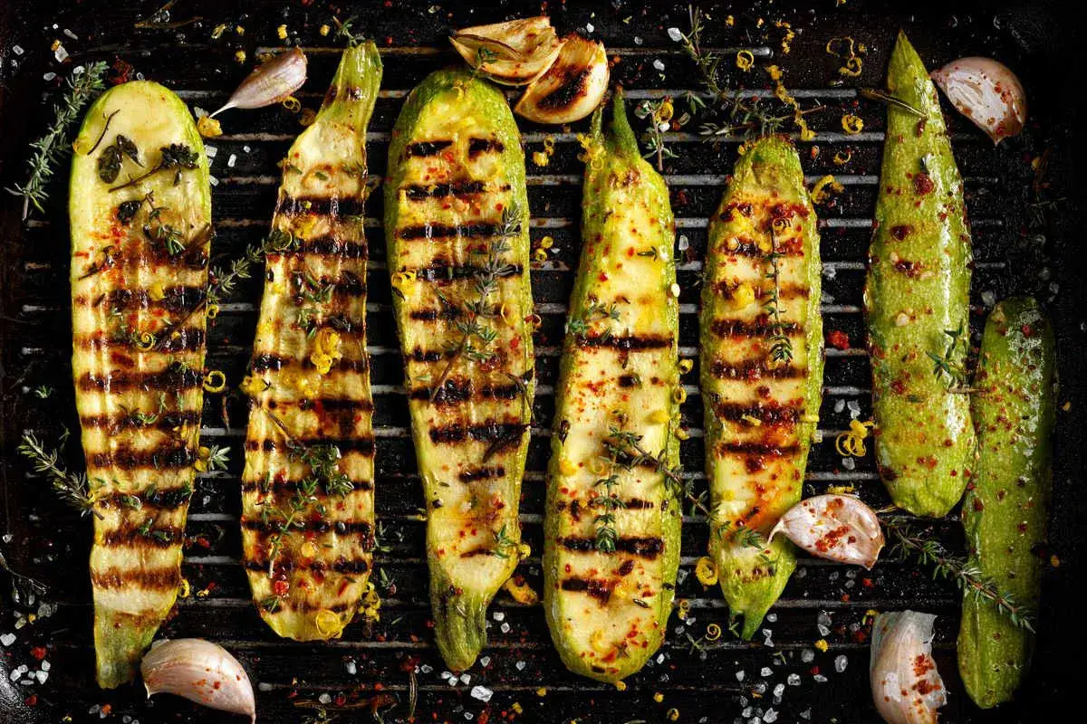 Zucchine grigliate come condirle: un contorno saporito con aglio, erbe aromatiche e scorza di limone.