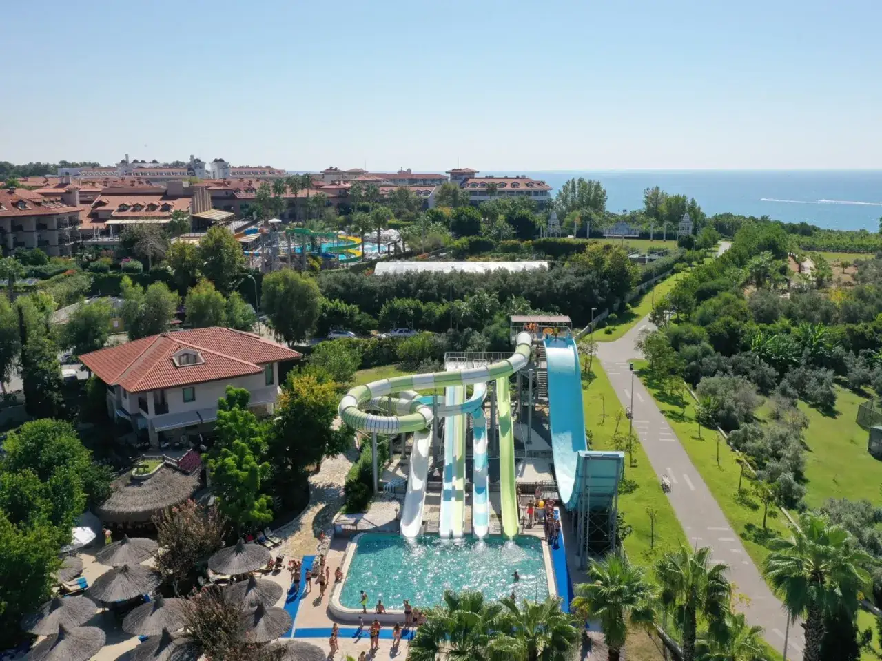 Ein Wasserpark mit Rutschen und Pool, daneben ein Hotelkomplex und das Meer. Ein perfekter Ort für einen Urlaub im club grand side.