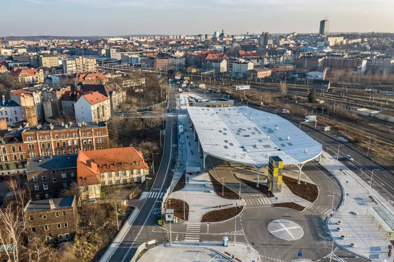 Widok z lotu ptaka na nowoczesny dworzec PKS w Katowicach. Obok widać tory kolejowe i zabudowania, co ułatwia zrozumienie, jak dojść z dworca PKP na dworzec PKS w Katowicach.