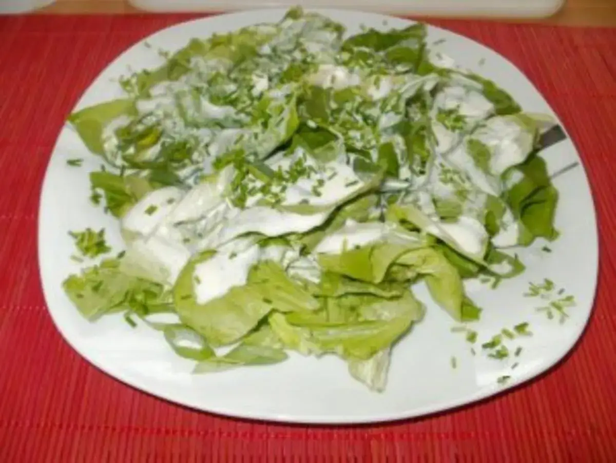 Frischer Salat mit cremigem salatdressing mit zitrone und zucker, bestreut mit Schnittlauch.
