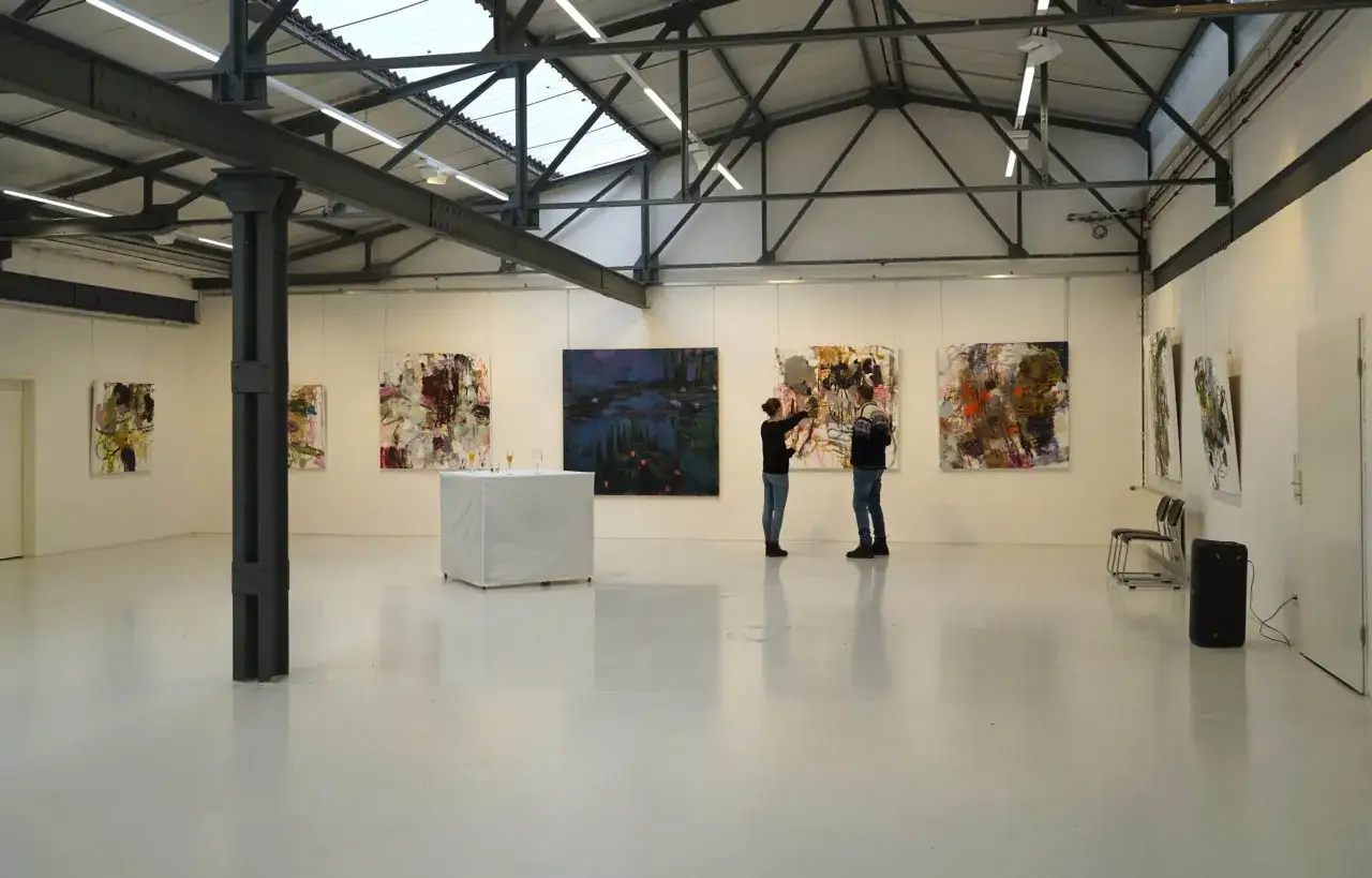 Zwei Besucher betrachten abstrakte Gemälde in der Kunsthalle Burkamp.