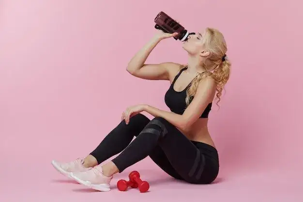Osoba pijąca shake proteinowy po treningu