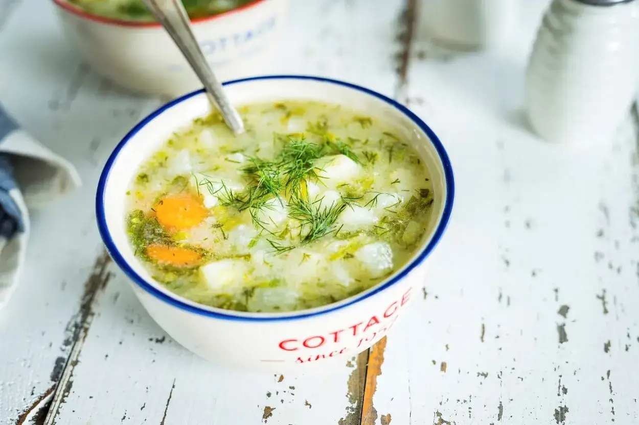 Aromaticzna zupa koperkowa z ziemniakami i marchewką, udekorowana świeżym koperkiem. Idealna na chłodne dni.
