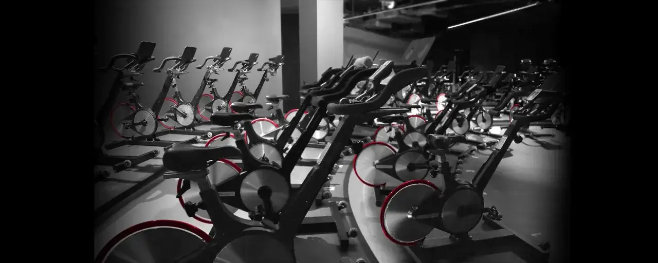 Reihe von Spinning-Rädern mit roten Akzenten, bereit für ein intensives Training.