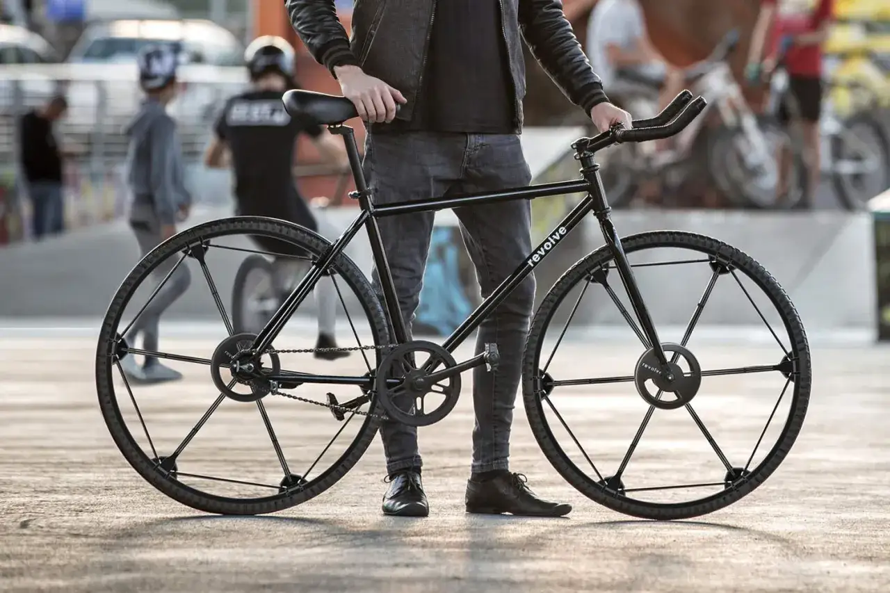 A person stands with a sleek black folding commuting bike, ready for urban adventures.