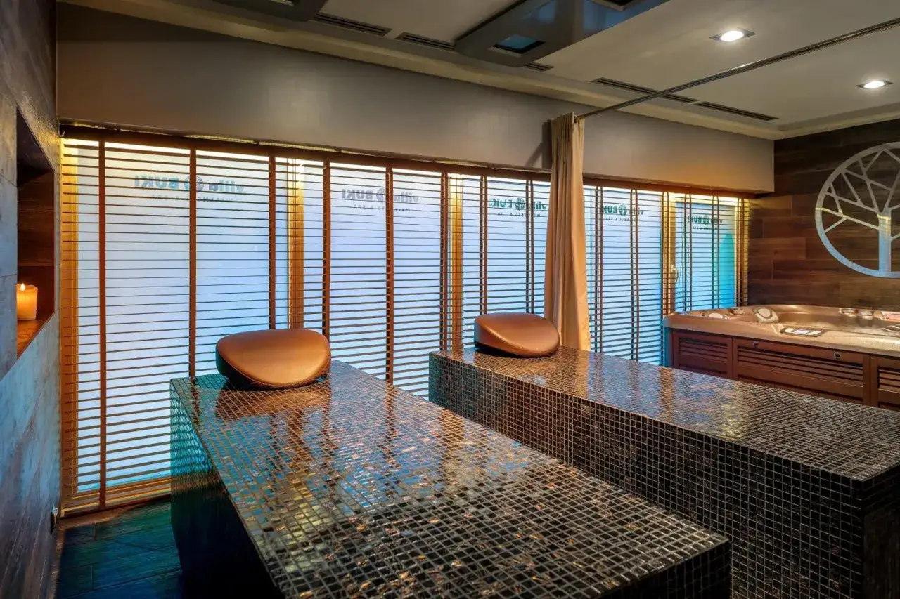 Relaks w spa willa Buki Jastrzębia Góra. Dwa łóżka do masażu, jacuzzi i świeca tworzą atmosferę spokoju.