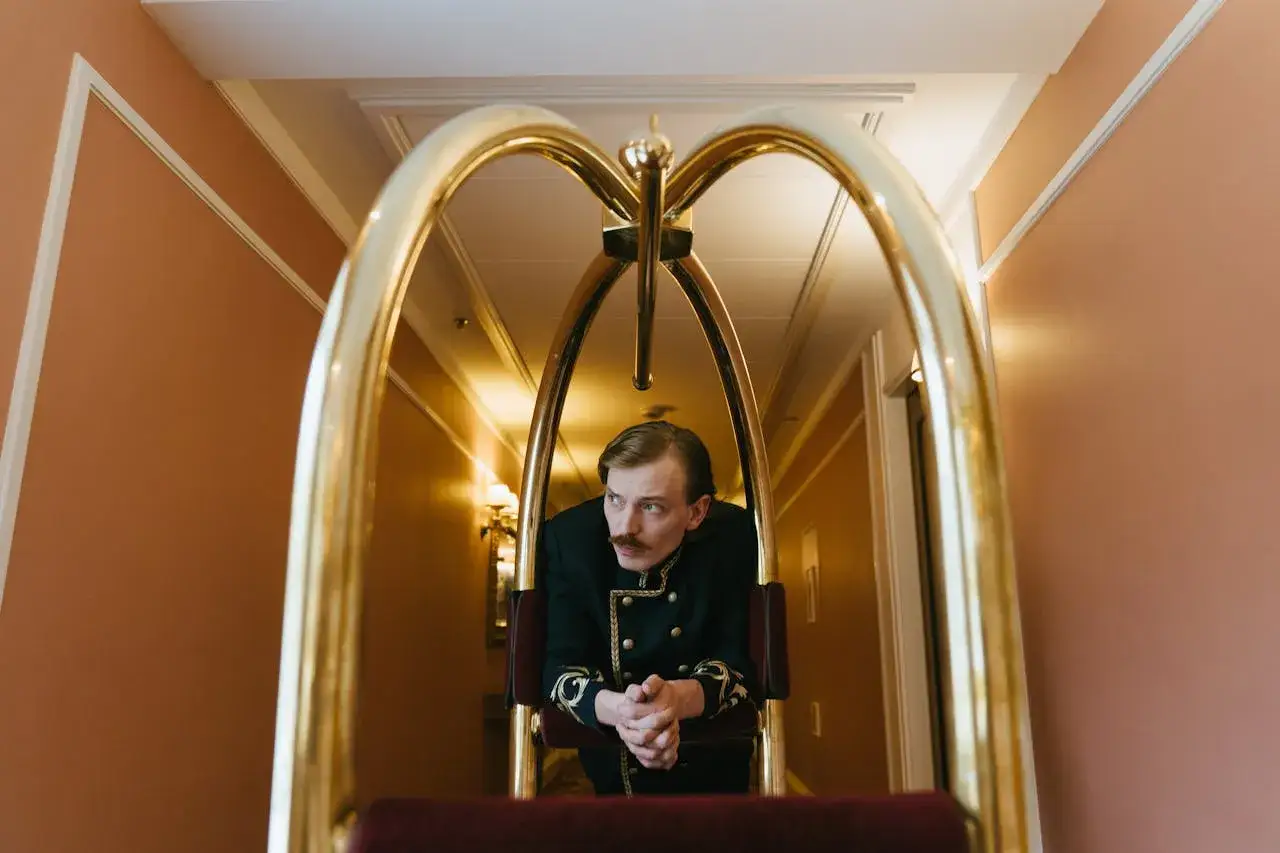 Portier w hotelowym wózku, zastanawia się, ile zarabia się w hotelu.