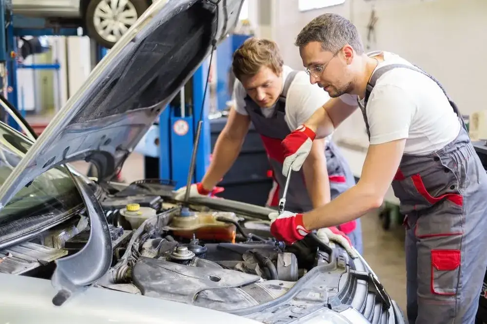 mécanicien changeant un filtre à gasoil dans un garage automobile