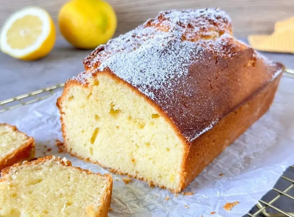Saftiger Zitronenkuchen, bestäubt mit Puderzucker. Ein schneller und einfacher Sonntagskuchen, der perfekt zu frischen Zitronen passt.