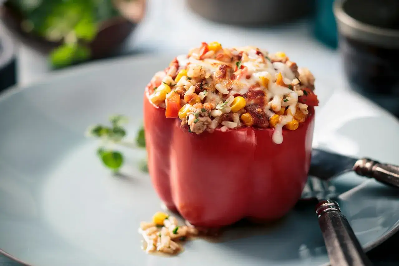 Pimiento rojo relleno de arroz, carne picada, ma&iacute;z y queso gratinado. Un plato casero y delicioso.