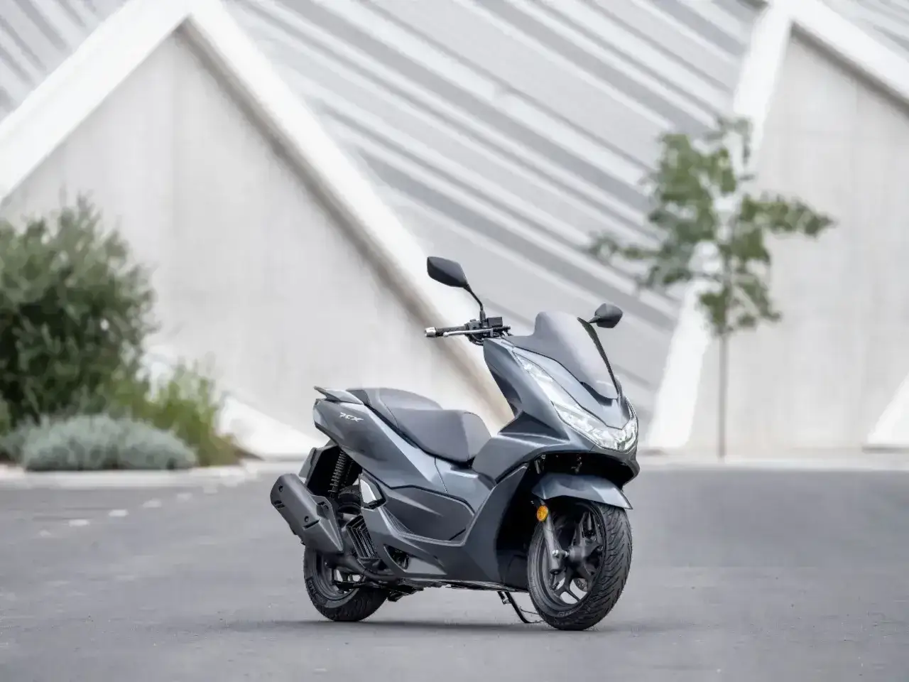 Szary skuter Honda PCX 125, gotowy na miejskie wyzwania. Niska awaryjność to jego atut.