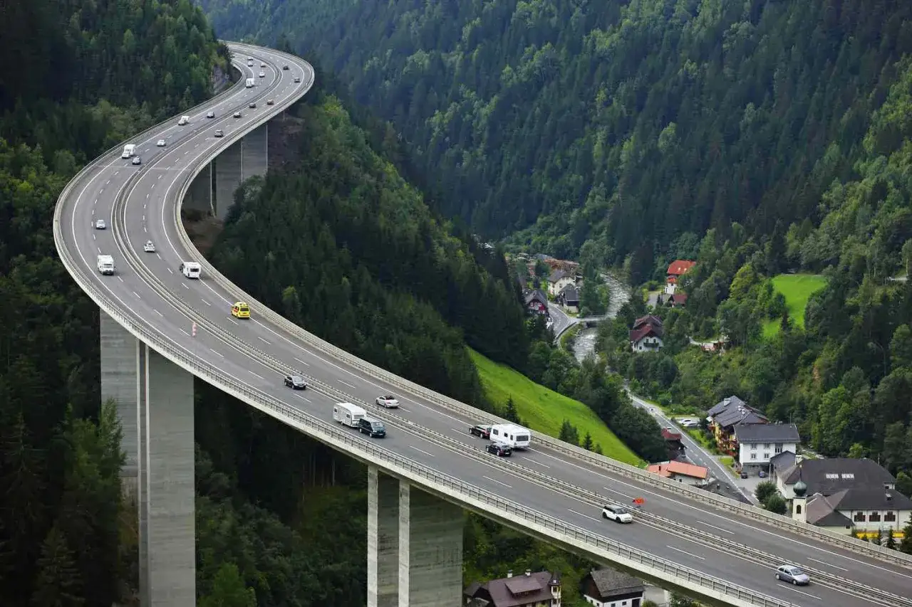 Autostrada w Austrii, z widokiem na dolinę i domy. Sprawdź e-winieta austria cena, by podróżować bez stresu.
