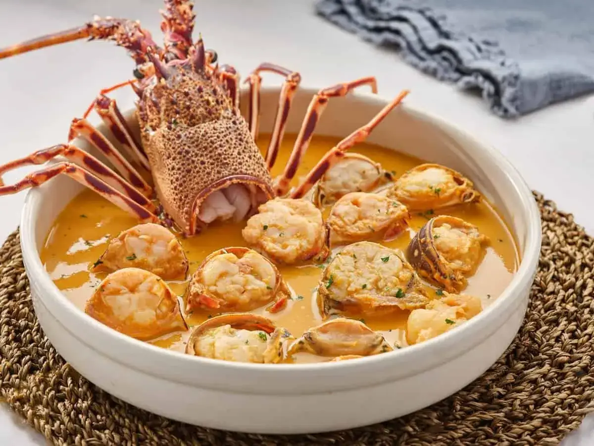Delicioso plato de langosta marisco en una cremosa salsa, con trozos de langosta y gambas.