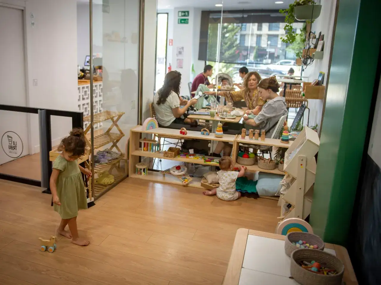 Niños jugando y familias disfrutando de un **brunch con niños Madrid**. Un espacio acogedor con juguetes y comida.