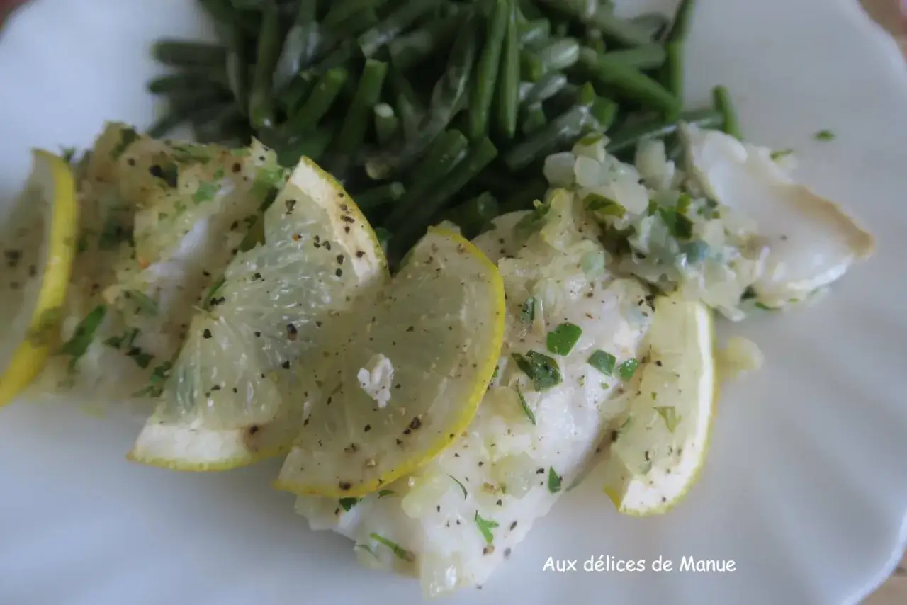 D&eacute;licieux dos de cabillaud au four, garni de rondelles de citron et d'herbes fra&icirc;ches, servi avec des haricots verts croquants.
