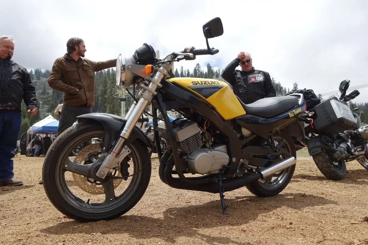 Żółty motocykl Suzuki GS 500 z czarnymi akcentami, obok stoją mężczyźni w kurtkach.