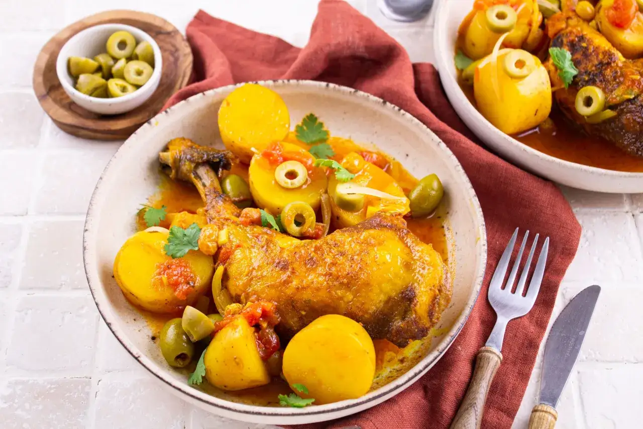 Un plat app&eacute;tissant de poulet aux olives, garni de pommes de terre et de persil frais, pr&ecirc;t &agrave; &ecirc;tre d&eacute;gust&eacute;.