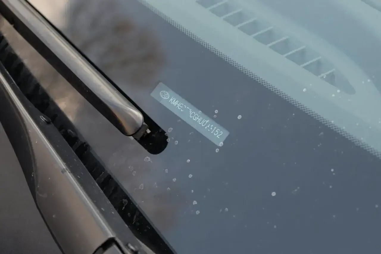 Naklejka z numerem VIN na szybie ułatwia rozkodowanie VIN Volvo. Widoczny numer to KMHG...CGHU0...152.