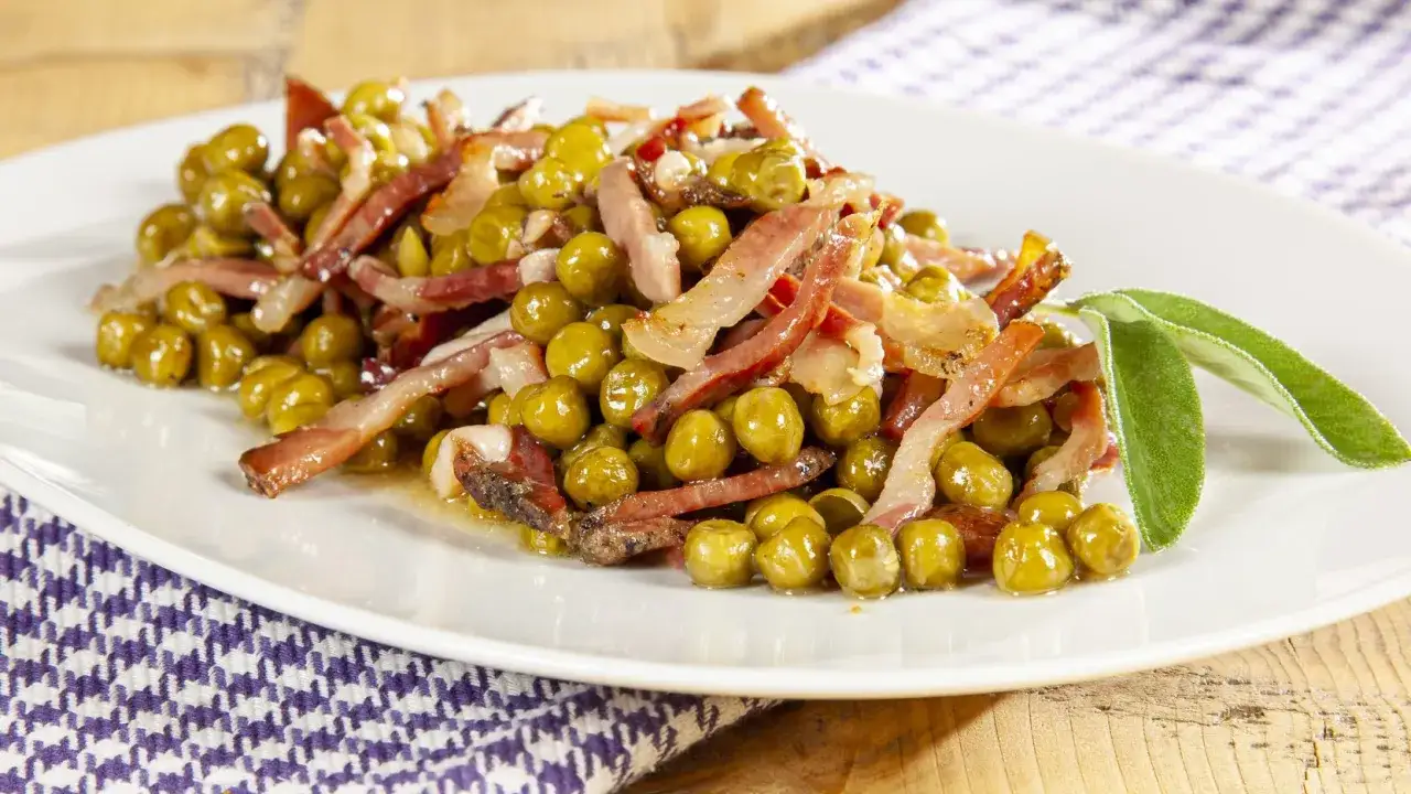 Un piatto di piselli e pancetta croccante, guarnito con foglie di salvia fresca. Un classico sapore italiano.