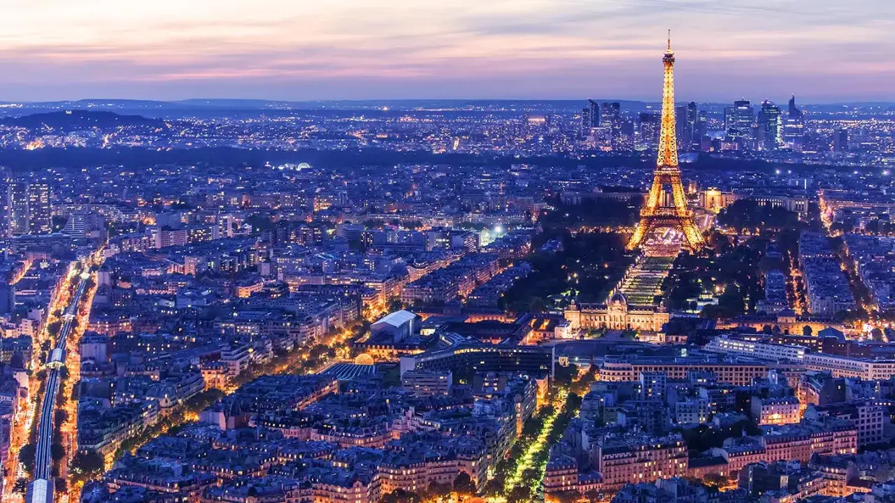 Paris vid skymning. Eiffeltornet lyser upp staden. Visste du att det finns roliga fakta om Eiffeltornet?