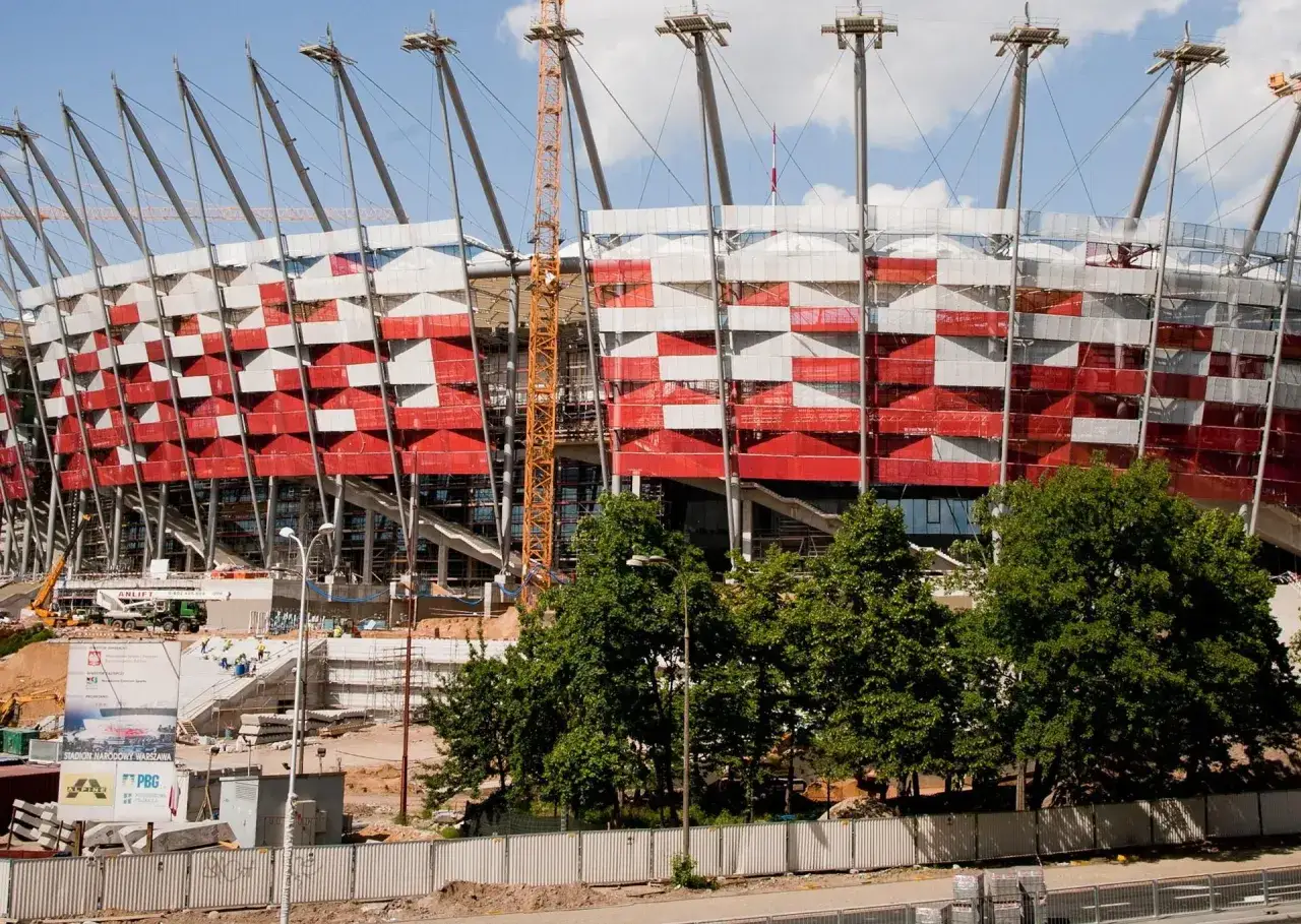 Stadion Narodowy w budowie, z charakterystyczną biało-czerwoną fasadą. Trudno oszacować, ile kosztował stadion narodowy, widząc te postępy prac.