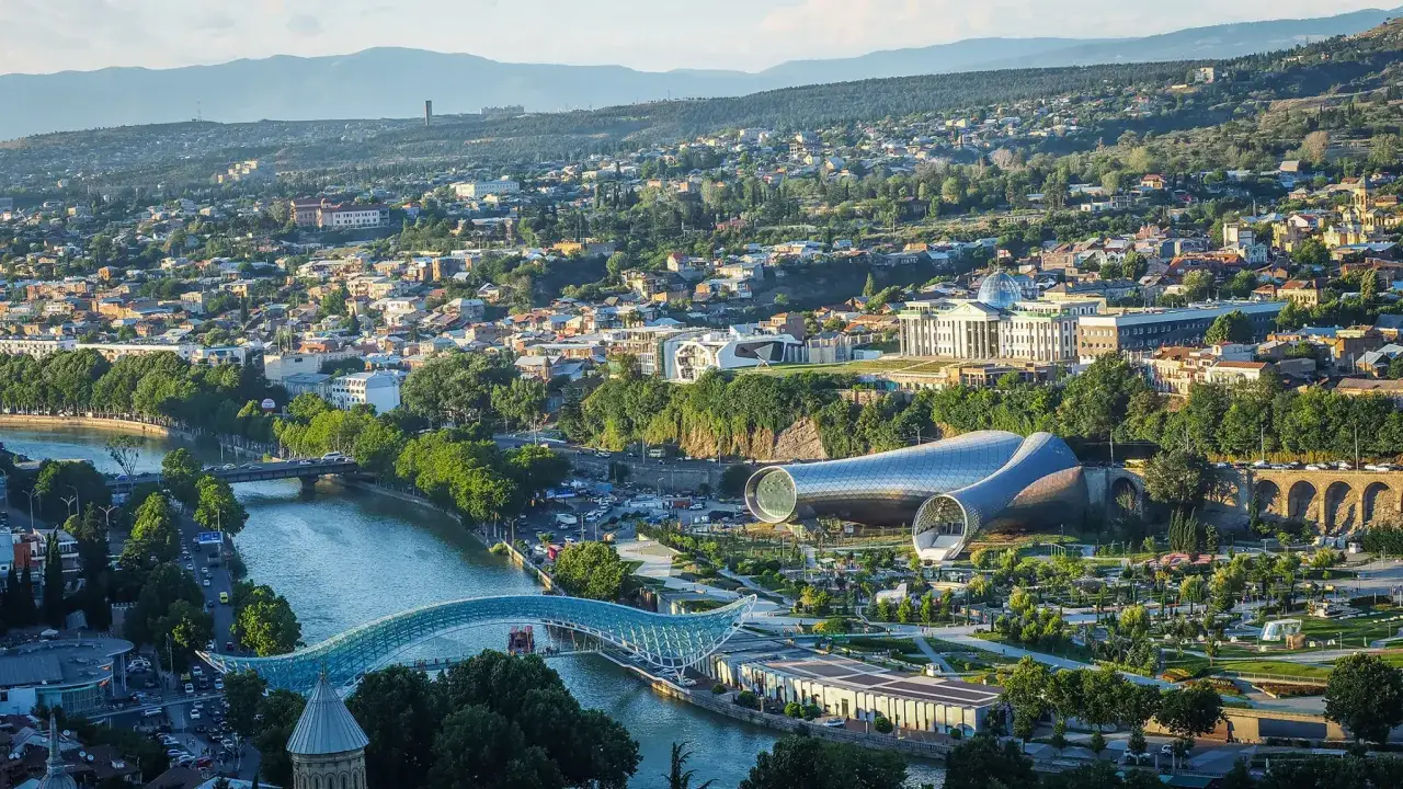 Widok na Tbilisi, gdzie rzeka Kura przepływa przez miasto, a nowoczesna architektura kontrastuje z historycznymi budynkami. Gruzja najpiękniejsze miejsca.