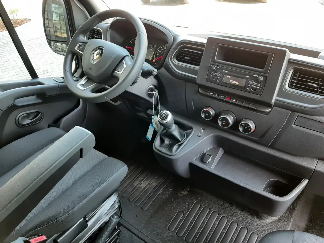 Wnętrze Renault Master 4: kierownica, dźwignia zmiany biegów, radio i siedzenie.