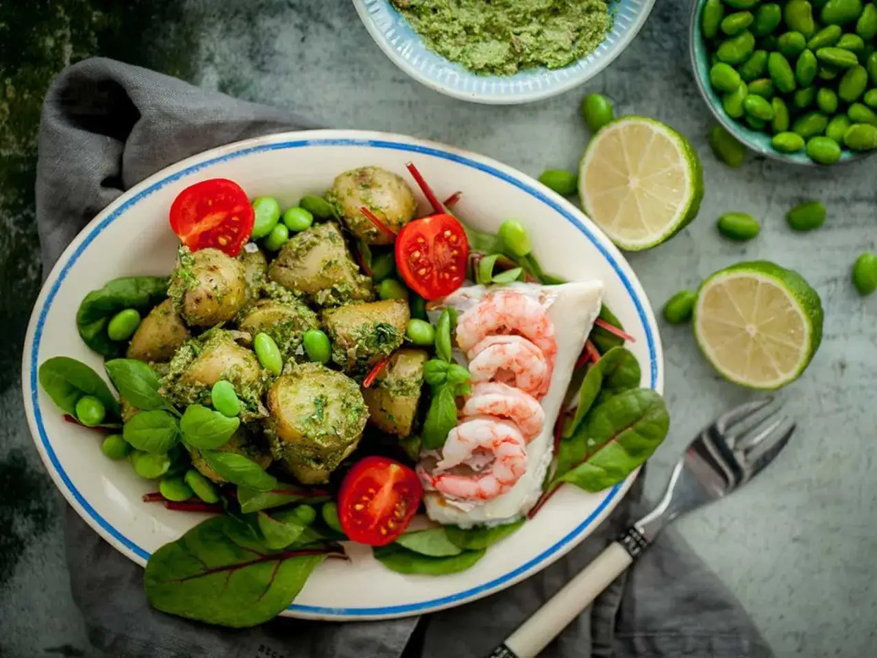 En härlig tallrik med torskrygg, potatis med pesto, edamamebönor och körsbärstomater. Ett perfekt torskrygg recept för en lätt och smakrik måltid.