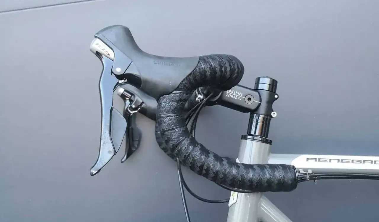 Czarna, wzorzysta owijka na kierownicę roweru z manetkami Shimano.