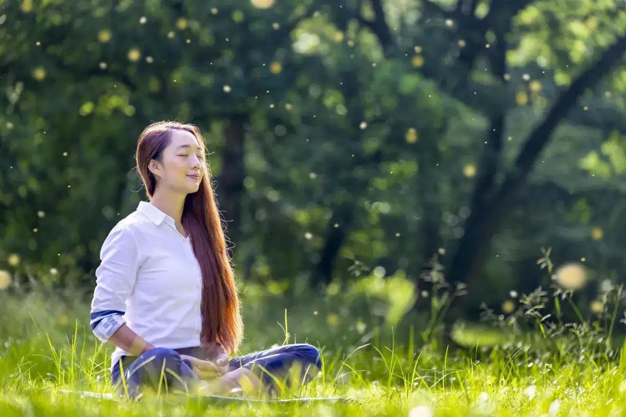 Mujer meditando en la naturaleza, buscando paz y fortaleza. Inspiración con versículos para mujeres.